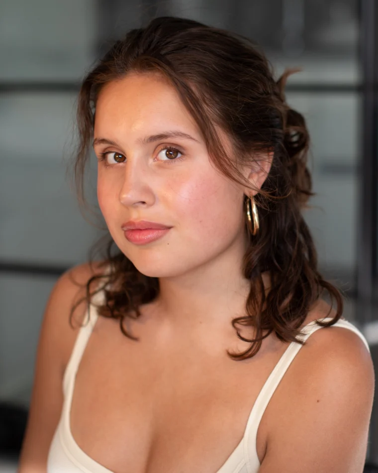Anastasia Borodina, actor, head-and-shoulders portrait in a cream tank top, three-quarter angle, looking softly off camera.