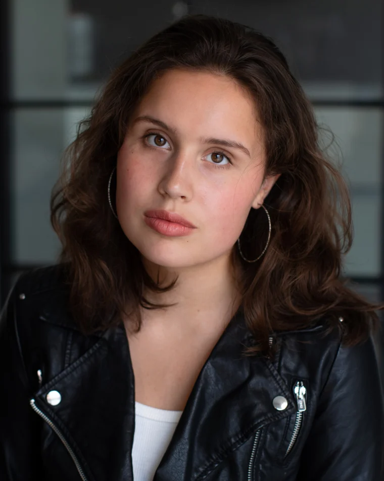 Anastasia Borodina, actor, head-and-shoulders portrait in a black leather jacket, chin raised, looking off camera.