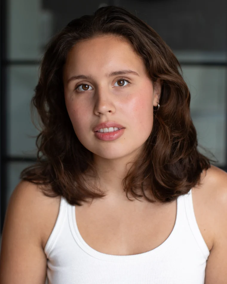 Anastasia Borodina, actor, head-and-shoulders portrait in a white ribbed tank top, neutral expression, looking directly at camera.